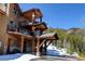 A three story home has a wooden exterior with a stone foundation and multiple covered decks at 10508 Christopher Dr, Conifer, CO 80433