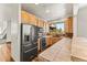 Well-lit kitchen features custom cabinetry, tile countertops, and stainless steel appliances at 10508 Christopher Dr, Conifer, CO 80433