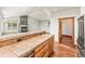 Open kitchen with tile countertops and views into the living room with a grand fireplace at 10508 Christopher Dr, Conifer, CO 80433