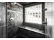 Stylish shower with built-in bench and textured tile, featuring a glass block window at 10508 Christopher Dr, Conifer, CO 80433