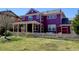Backyard with green grass, white picket fence and two-story purple house, perfect for entertaining or relaxing at 8335 E 22Nd Ave, Denver, CO 80238