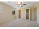This bedroom features neutral paint, a ceiling fan, carpet, and two walk in closets at 8335 E 22Nd Ave, Denver, CO 80238