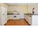 Bright kitchen with stainless steel appliances, white cabinetry, and laminate wood flooring at 8335 E 22Nd Ave, Denver, CO 80238