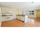 Open concept kitchen featuring white cabinetry, modern appliances and breakfast bar overlooking the living room at 8335 E 22Nd Ave, Denver, CO 80238