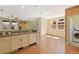 View of kitchen, dining area, stairway and laundry room with laminate wood floors and stainless appliances at 8335 E 22Nd Ave, Denver, CO 80238
