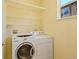 Bright laundry room with stacked washer and dryer, storage shelves, and window at 8335 E 22Nd Ave, Denver, CO 80238
