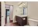Well-lit bathroom featuring a modern vanity with storage and a toilet next to a doorway at 13691 E Marina Dr # 107, Aurora, CO 80014