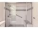 Modern shower with glass doors, tiled walls, shower head, and grab bars for accessibility and safety at 13691 E Marina Dr # 107, Aurora, CO 80014