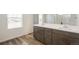 Bathroom features double sinks with modern fixtures, stylish wood-look flooring, and great natural light from a nearby window at 2177 Garden Ave, Brighton, CO 80601