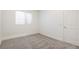 Neutral bedroom featuring wall-to-wall carpet, a window, and a door at 2177 Garden Ave, Brighton, CO 80601