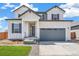 Attractive two-story home with a well-manicured lawn, porch, and garage at 2177 Garden Ave, Brighton, CO 80601