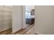 Hallway leading to an open kitchen area with island and adjacent shelving units at 2177 Garden Ave, Brighton, CO 80601