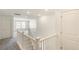 Upstairs hallway featuring neutral colored carpet and white railing with multiple doors at 2177 Garden Ave, Brighton, CO 80601