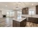 Stylish kitchen and living area with stainless steel appliances, island, and fireplace nearby at 2177 Garden Ave, Brighton, CO 80601