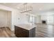 Open-concept space featuring a kitchen island, fireplace, and staircase leading to the upper level at 2177 Garden Ave, Brighton, CO 80601