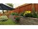 Landscaped backyard with a privacy fence, flower garden, and a patio umbrella for shade at 19447 E Bellisario Creek Dr, Parker, CO 80134