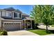 A two story gray home with a two car garage sits on a well manicured corner lot at 19447 E Bellisario Creek Dr, Parker, CO 80134