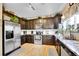 Well-equipped kitchen with stainless steel appliances, granite countertops, and dark wood cabinets at 19447 E Bellisario Creek Dr, Parker, CO 80134