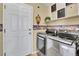 Laundry room features stainless steel washer and dryer, storage, and a white door at 19447 E Bellisario Creek Dr, Parker, CO 80134
