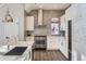 White kitchen with stainless steel appliances and gray tile backsplash at 2951 E Evans Ave, Denver, CO 80210