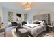 Main bedroom with a tufted headboard and sitting area at 2951 E Evans Ave, Denver, CO 80210