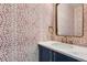 Stylish powder room with navy vanity, marble countertop, and patterned wallpaper at 2951 E Evans Ave, Denver, CO 80210