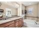 Bright bathroom featuring double vanity, soaking tub, and stylish tile work at 8157 E 53Rd Dr, Denver, CO 80238