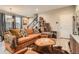 Inviting living room with an orange couch, area rug, and staircase access at 8157 E 53Rd Dr, Denver, CO 80238