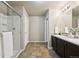 Bright bathroom featuring a double sink vanity and walk-in shower with glass doors at 443 Hermosa St, Brighton, CO 80603