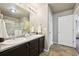 A bathroom featuring double sinks, a large mirror, and a walk-in shower with glass doors at 443 Hermosa St, Brighton, CO 80603