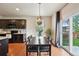 Cozy dining area next to the kitchen featuring modern light fixture and backyard access at 443 Hermosa St, Brighton, CO 80603