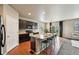 Modern kitchen with dark cabinetry, island seating, and stainless steel appliances at 443 Hermosa St, Brighton, CO 80603