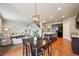 Open kitchen and dining area with modern lighting fixtures, island and black appliances at 443 Hermosa St, Brighton, CO 80603