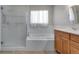 Bright bathroom featuring white tiled tub, separate glass door shower, and sink at 3563 Watada Dr, Brighton, CO 80601