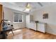 Bright, airy bedroom features hardwood floors, built-ins, and a ceiling fan at 3563 Watada Dr, Brighton, CO 80601