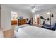 Bright bedroom features a ceiling fan, en suite bathroom, and fitness equipment at 3563 Watada Dr, Brighton, CO 80601