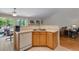 Bright kitchen with white dishwasher and counters, wood cabinets, and an adjacent dining area at 3563 Watada Dr, Brighton, CO 80601