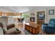 Open living room with fireplace, wooden floors, and natural light adjacent to kitchen and dining area at 3563 Watada Dr, Brighton, CO 80601