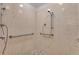 Accessible shower featuring a roll-under sink, accessible shower with bars and tiled flooring at 3563 Watada Dr, Brighton, CO 80601