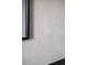 Close-up of neutral tile bathroom wall with black framed mirror, showcasing textured and modern design at 5031 Moss Pl, Golden, CO 80403