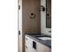 Bathroom vanity with light wood cabinets, black hardware, sleek sink, and modern fixtures at 5031 Moss Pl, Golden, CO 80403