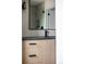 Bathroom vanity featuring sleek black faucet, light wood cabinets, and black framed mirror at 5031 Moss Pl, Golden, CO 80403