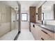 Modern bathroom showcasing a glass shower enclosure, sleek vanity with black fixtures, and a large mirror at 5031 Moss Pl, Golden, CO 80403