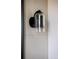 Modern bathroom light fixture with a sleek glass shade, mounted on a neutral tiled wall at 5031 Moss Pl, Golden, CO 80403