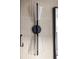 Modern bathroom sconce with clear glass shades and black hardware, complements the neutral tiled walls at 5031 Moss Pl, Golden, CO 80403