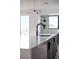 Close-up of a kitchen island featuring a modern faucet, sleek countertops, and stylish pendant lighting at 5031 Moss Pl, Golden, CO 80403