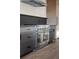 Close-up of a large stainless steel range oven, complete with kitchen hood and dark gray cabinets at 5031 Moss Pl, Golden, CO 80403