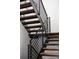 Modern staircase featuring wood steps, black metal railings, and bright natural light at 5031 Moss Pl, Golden, CO 80403