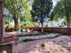 Spacious backyard with a stone pathway, fire pit, colorful chairs, and mature trees at 3401 N Steele St, Denver, CO 80205