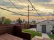 Inviting backyard with wooden deck, privacy fence, small lawn, and detached garage at 3401 N Steele St, Denver, CO 80205